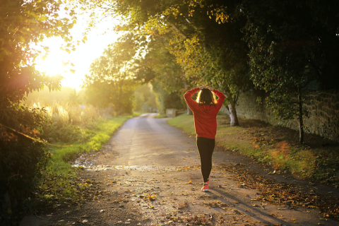 Woman walking down a hiking path on a sunny day