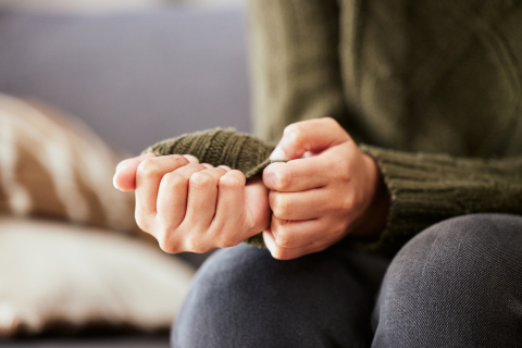 woman clasping her hands together while experiencing anxiety